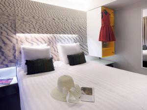 a bedroom with a bed with a hat on it at ibis Styles Amsterdam Central Station in Amsterdam