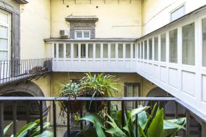 ナポリにあるResidenza Principe di Carafaのバルコニーと植物のあるアパートメントビル