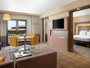 a living room with a couch and a room with a bed at Novotel Istanbul Bosphorus Hotel in Istanbul