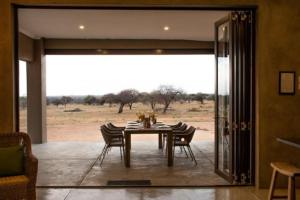 a dining room with a table and chairs and a field at The Barnhouse in Hammanskraal +9 photos