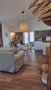 a living room with a couch and a table and a kitchen at Quintinha do Sal - Casa das Flores in Alcácer do Sal