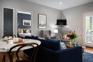 a living room with a blue couch and a table at Lake Orchard Villas in Daylesford