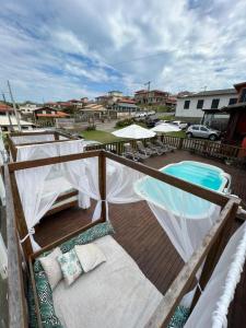 een balkon met stoelen en een zwembad bij Pousada Vista ao Farol in Farol de Santa Marta