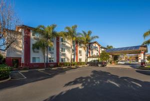 a parking lot in front of a building with palm trees at Comfort Inn Gilroy in Gilroy
