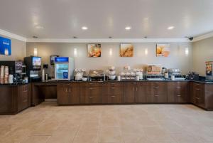 a large room with a coffee shop with wooden cabinets at Comfort Inn Gilroy in Gilroy