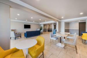 a waiting room with tables and yellow chairs at Comfort Inn Gilroy in Gilroy