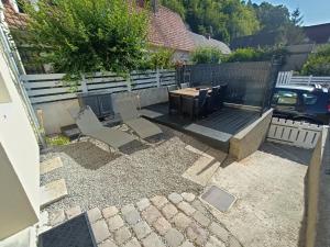 een achtertuin met een tafel en stoelen en een hek bij Agréable maison 3* en bord de mer in Dieppe