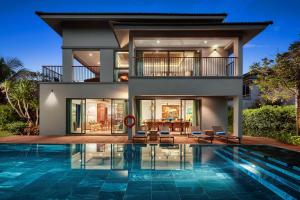a house with a swimming pool in front of a house at Best Western Premier Sonasea Villas Phu Quoc in Phu Quoc