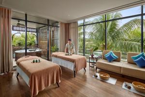 富國的住宿－Best Western Premier Sonasea Villas Phu Quoc，站在酒店房间,带两张床的男人