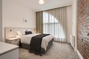 una camera da letto con un letto grande e un muro di mattoni di Castle Buildings a Belfast