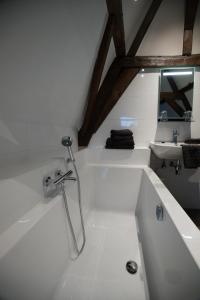 a bathroom with a bath tub with a sink at Logement de Spaerpot in Middelburg