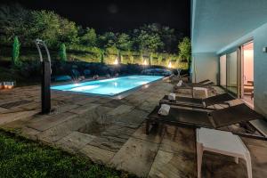 a swimming pool in a backyard at night at Winzervilla Klöch in Klöch