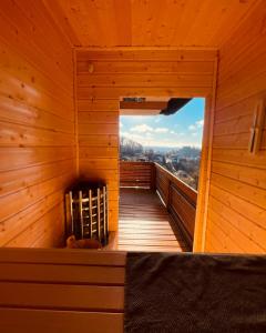 Habitación con cama en una cabaña de madera con ventana en Private Spa Lodge Odenwald, en Lindenfels