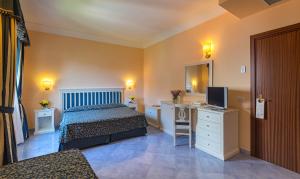 a hotel room with a bed and a television at Hotel Jaccarino in SantʼAgata sui Due Golfi