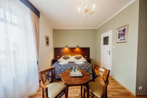 a bedroom with a bed and a table with chairs at Park Hotel Kur & Spa in Świeradów-Zdrój