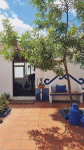 eine Terrasse mit einem Baum und einer Bank neben einem Gebäude in der Unterkunft Quintinha do Sal - Casa das Flores in Alcácer do Sal