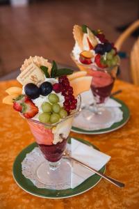 dos vasos de helado y ensalada de frutas en una mesa en Landhotel Tanneneck - ideal für Gruppen, Familien und Hunde en Löffingen