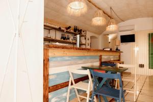 モルフェッタにあるA Stare - Stone Apartment in the Historic Center - Molfettaのテーブルと椅子、バーが備わる客室です。