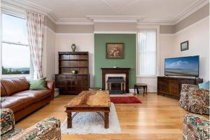 ein Wohnzimmer mit Sofa und Tisch in der Unterkunft St Katherines in Llandudno