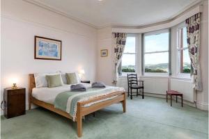 a bedroom with a bed and a large window at St Katherines in Llandudno