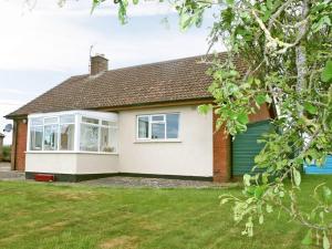 a detached house with a garage in a yard at Merryview Bungalow in Orcop