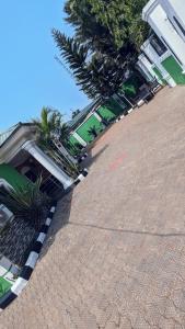 un patio con palmeras y un edificio en Naboya House Serviced Apartment, en Benin City