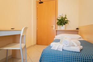 a hotel room with a bed with towels on it at Hotel Fantasy in Rimini