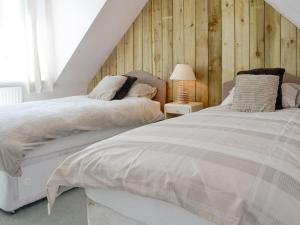 two beds sitting next to each other in a bedroom at South Cross Slacks Farmhouse in Crovie