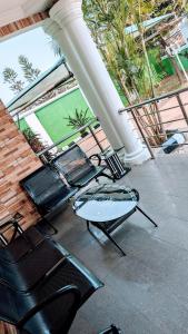 - un ensemble de chaises et de tables sur une terrasse dans l'établissement Naboya House Serviced Apartment, à Benin City