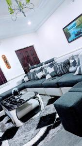 - un salon avec un canapé et une télévision dans l'établissement Naboya House Serviced Apartment, à Benin City