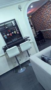 a living room with a couch and a bar counter at Naboya House Serviced Apartment in Benin City