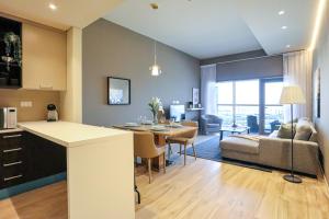 cocina y sala de estar con mesa y sofá en WelHome - Evergreen Apartment Amidst Vibrant JVC With Pool, en Dubái