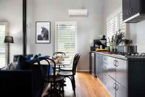 uma cozinha com mesa e cadeiras num quarto em Lake Orchard Villas em Daylesford