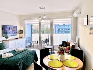 a living room with a bed and a table with chairs at Baltic Comfort Apartment in Kołobrzeg