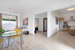 a living room with a glass table and a kitchen at Casa Abubilla in Nazaret