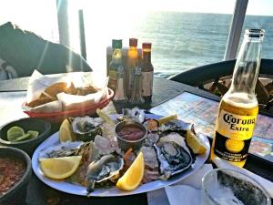 a table with a plate of oysters and a bottle of beer at 5 bedroom Beachfront pool & Spa in Ensenada