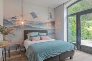 1 dormitorio con 1 cama con pájaros en la pared en Superbe appartement 2 chambres dans un clos privé proche de Waterloo, en Genappe
