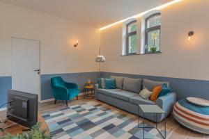 a living room with a couch and a tv at Superbe appartement 2 chambres dans un clos privé proche de Waterloo in Genappe