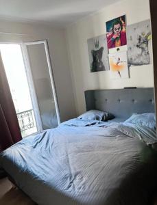 Schlafzimmer mit einem Bett, einem Spiegel und einem Fenster in der Unterkunft Elegance et Confort - Votre Havre Luxueux pour les Jeux Olympiques à Paris in Puteaux