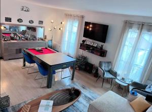 ein Wohnzimmer mit einem Tisch und Stühlen in der Unterkunft Elegance et Confort - Votre Havre Luxueux pour les Jeux Olympiques à Paris in Puteaux