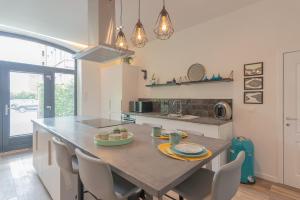 cocina con mesa con sillas y encimera en Superbe appartement 2 chambres dans un clos privé proche de Waterloo, en Genappe