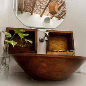 een badkamer met een houten bad en een spiegel bij Pousada Vila Cacau in Serra Grande
