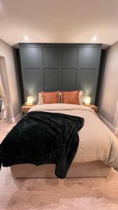 a bedroom with a large bed with a black headboard at CHAMBERS RISE - City Centre Stays in Derry Londonderry
