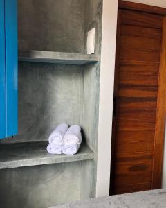 3 rouleaux de serviettes sur une étagère dans une salle de bains dans l'établissement Pousada Vila Lua Bela, à Pitimbu