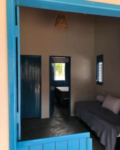 a room with a bed and a door with a window at Pousada Vila Lua Bela in Pitimbu