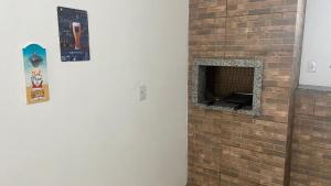 pared de ladrillo con chimenea en una habitación en Apartamento com área Gourmet Arroio do Silva, en Arroio do Silva