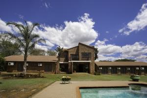 ein großes Backsteinhaus mit Pool davor in der Unterkunft Peter's Guesthouse in Pretoria