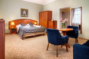 シフィエラドゥフ・ズドルイにあるPark Hotel Kur & Spaのベッドルーム1室(ベッド1台、テーブル、椅子付)