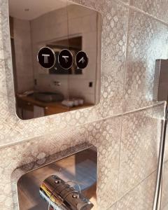 a mirror in a bathroom with a gun in it at Private Spa Lodge Odenwald in Lindenfels