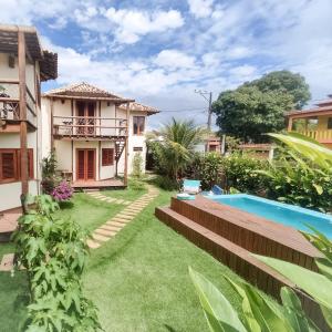 a garden with a swimming pool and a house at Pousada Vila Cacau in Serra Grande